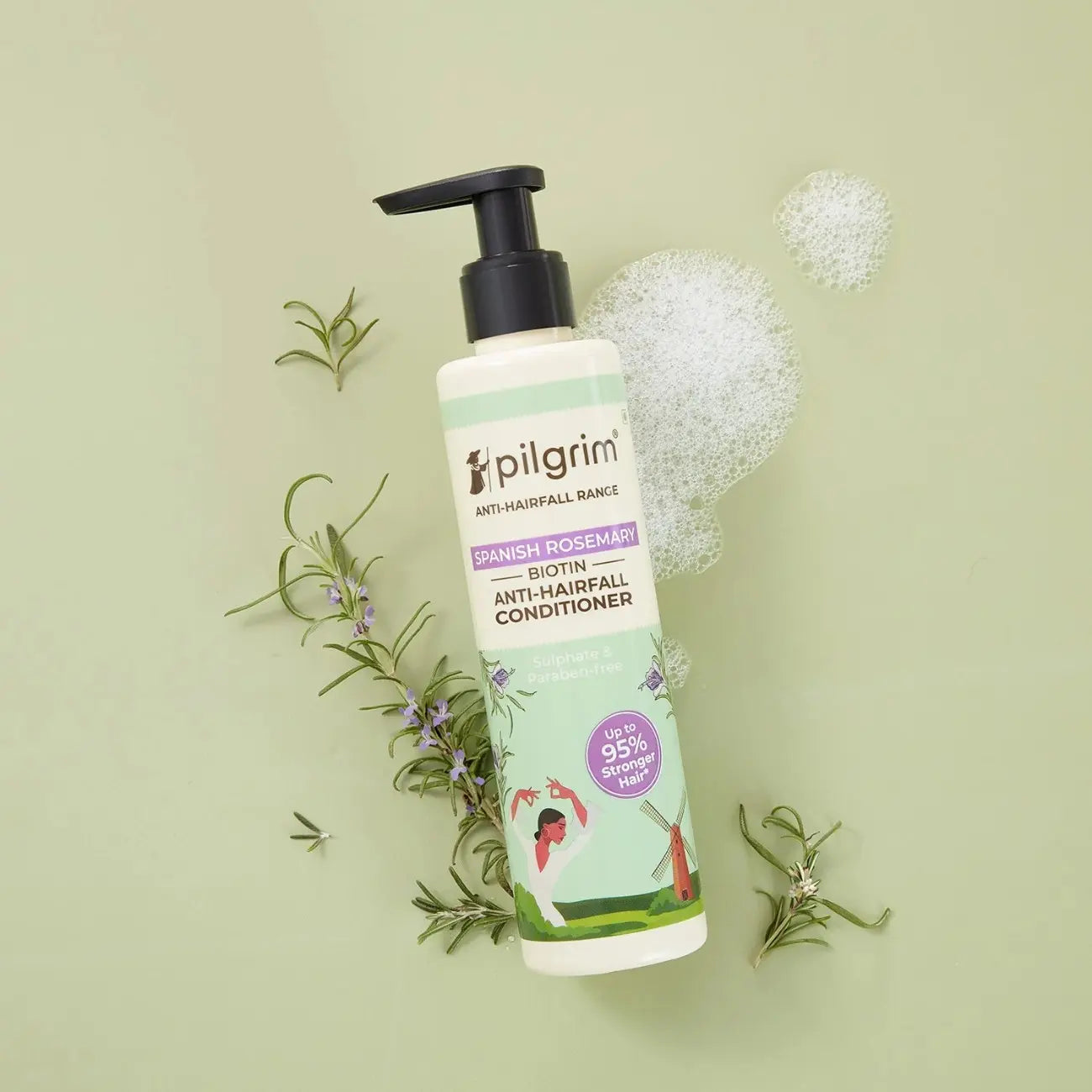Pilgrim anti-hairfall conditioner bottle with rosemary leaves on a light green background